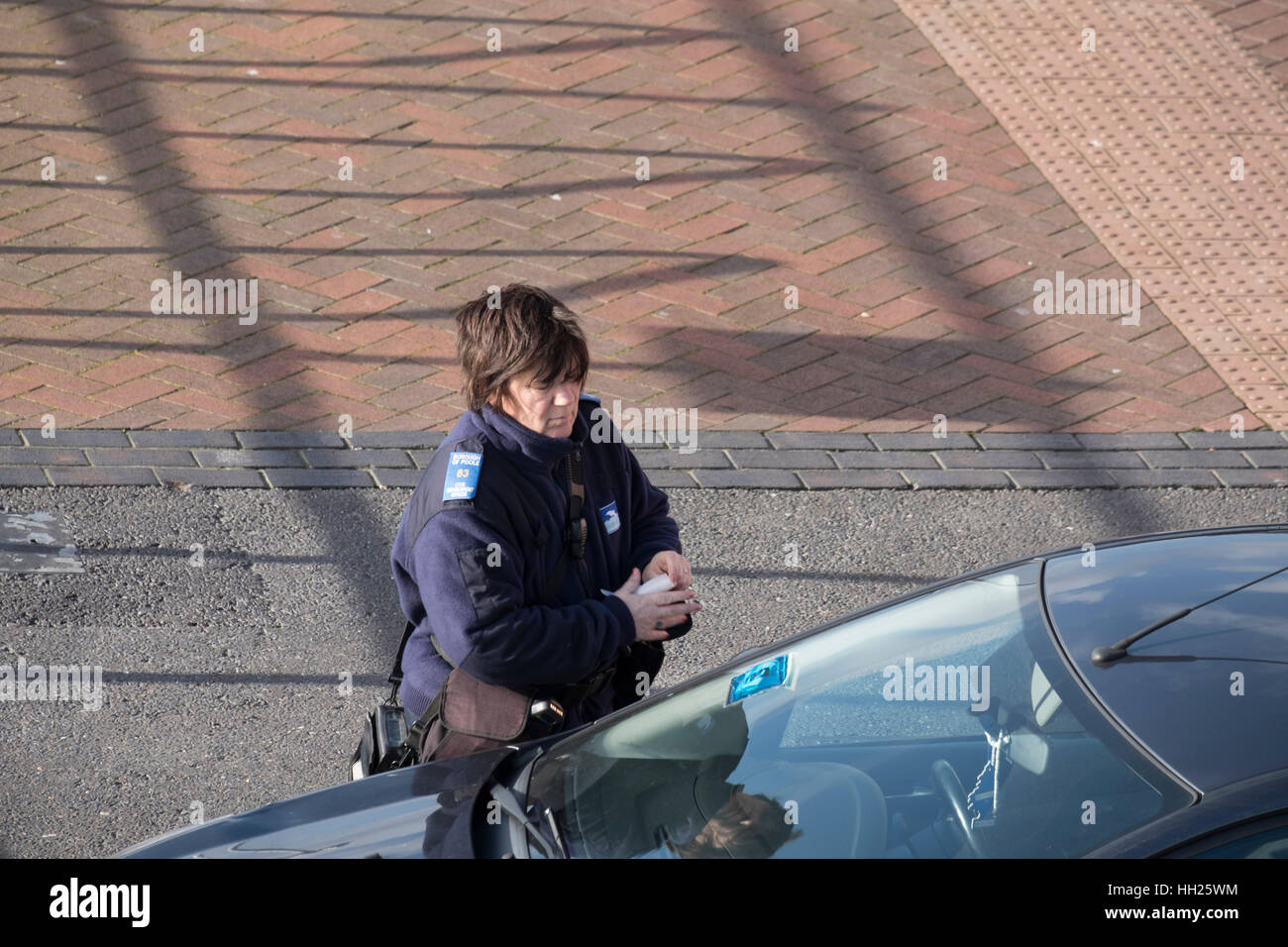 Vigile di emettere un biglietto parcheggio om quay Poole Dorset su una macchina parcheggiata in area doganale. Foto Stock