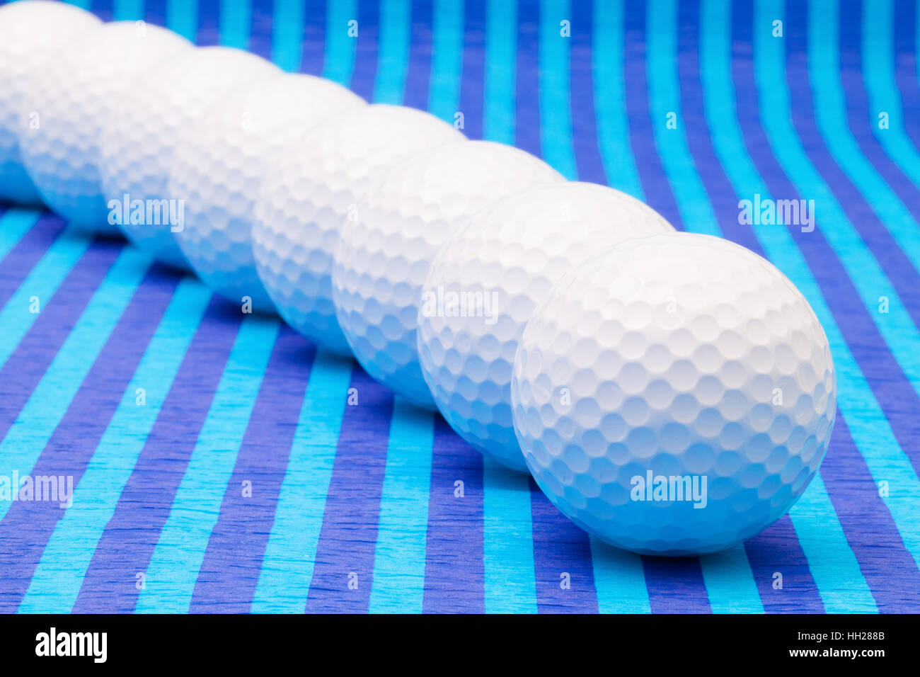 White palline da golf su strisce blu tovaglia. Foto Stock