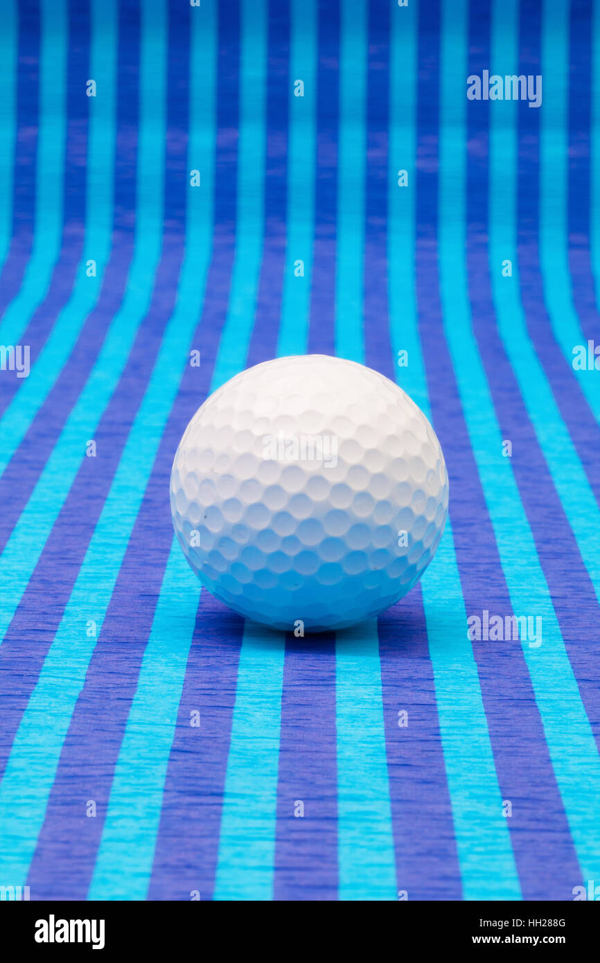 White pallina da golf su strisce blu tovaglia. Foto Stock