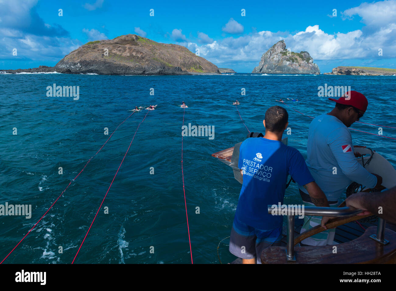 I turisti lo snorkeling off il brasiliano Atlantic isola di Fernando de Noronha, ciascuno è tirato da una barca, Pernambuco, Brasile Foto Stock