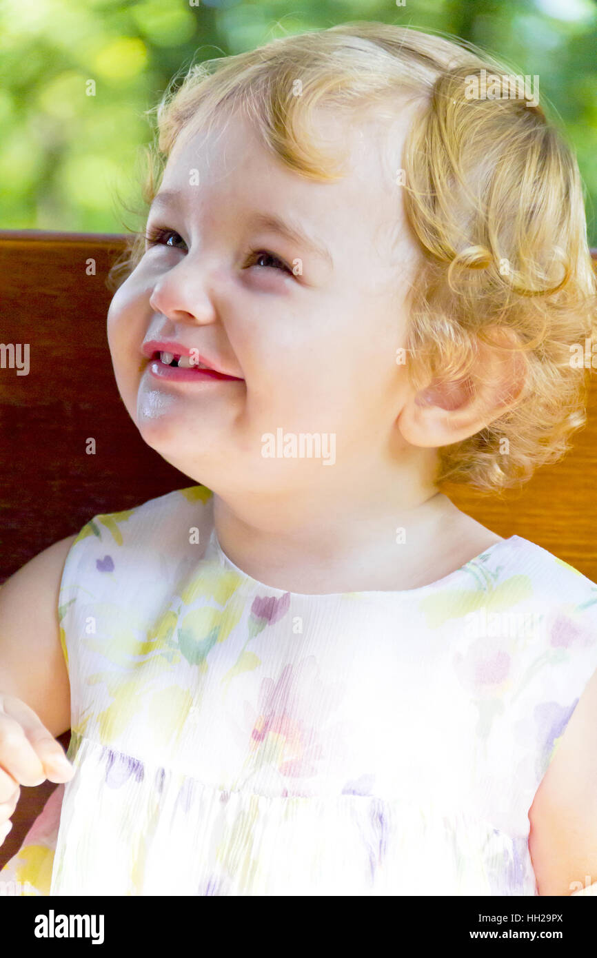 Ritratto di sorridente bambina con ricci capelli biondi Foto Stock