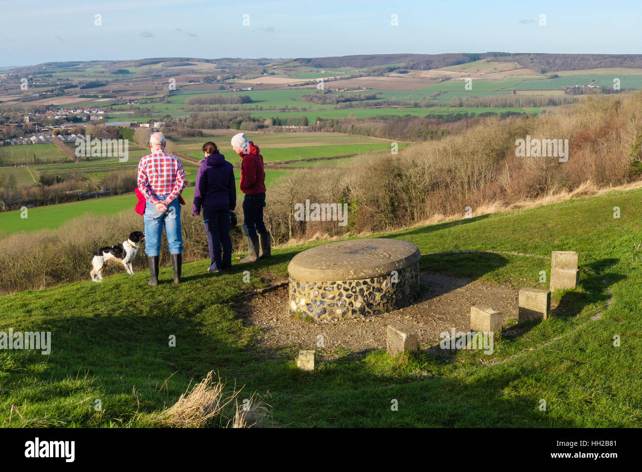 Persone che guardano a vista dalla corona Wye Millennium stone a Wye Riserva Naturale Nazionale in colline su North Downs lungo Wye Downs. Kent REGNO UNITO Foto Stock
