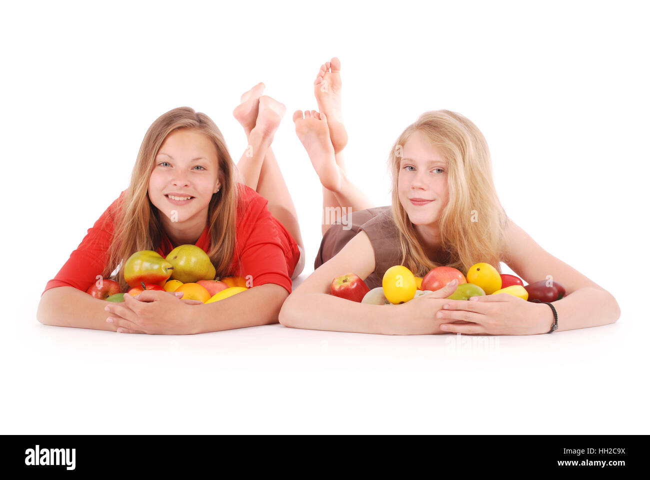 Due ragazze azienda frutta fresca isolato su bianco Foto Stock