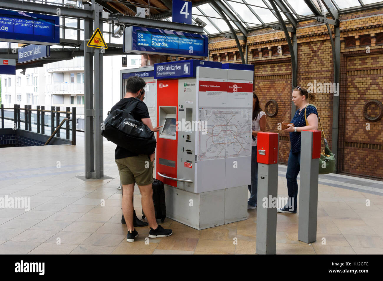 Pendolari acquisto biglietti da una biglietteria automatica sulla piattaforma a Berlino Hackescher Markt station, Berlino, Germania. Foto Stock