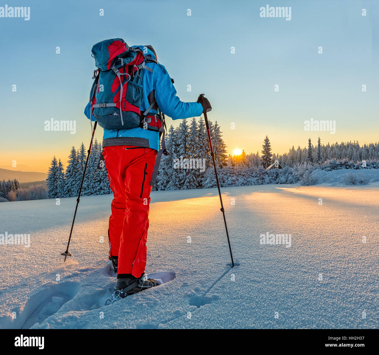 Escursioni con le racchette da neve walker in esecuzione in polvere di neve con bellissima alba luce. Outdoor attività invernali e uno stile di vita sano Foto Stock