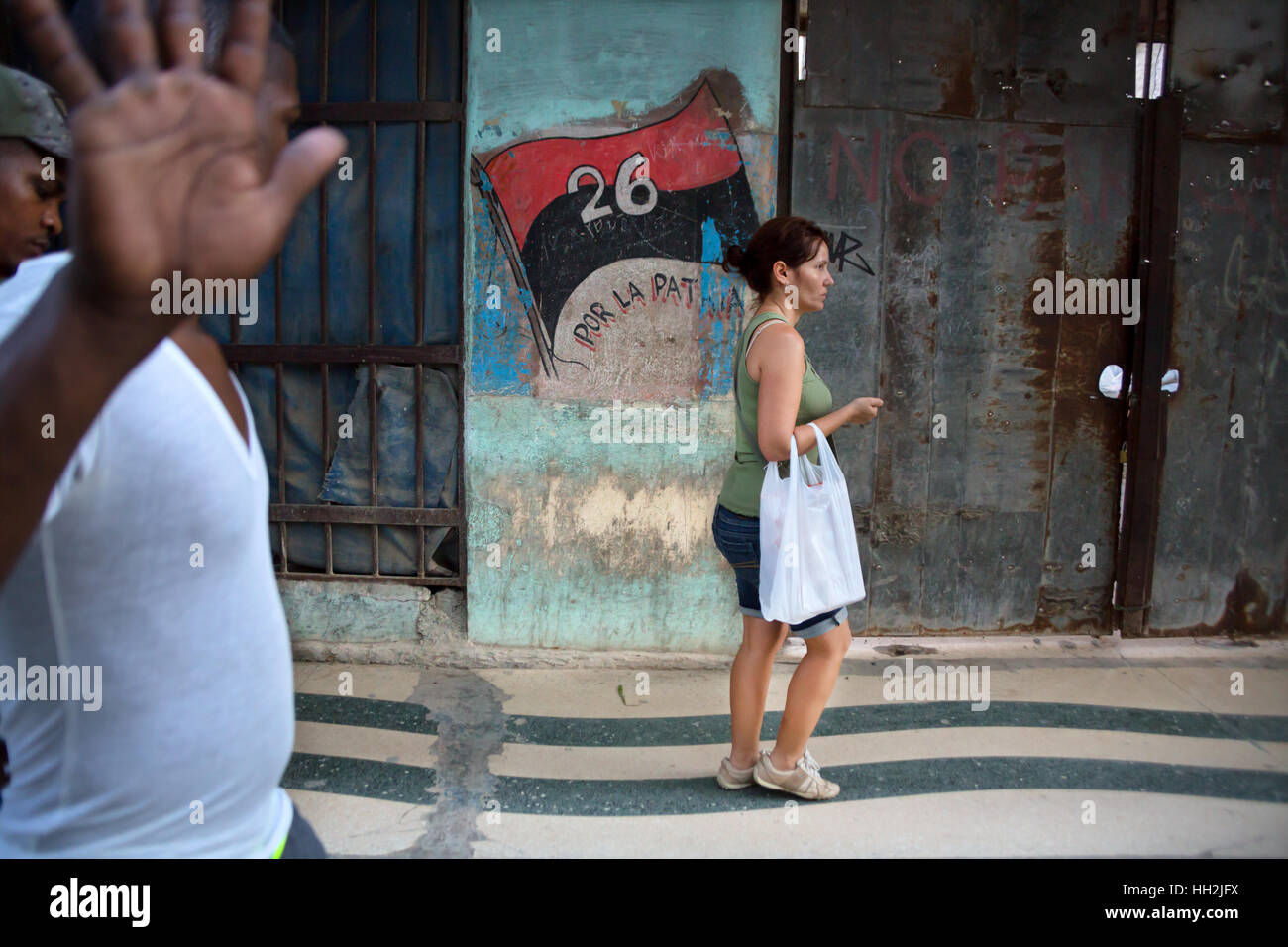 Cuba - le persone camminare per le strade di l'Avana con il 26 luglio segno su una parete Foto Stock