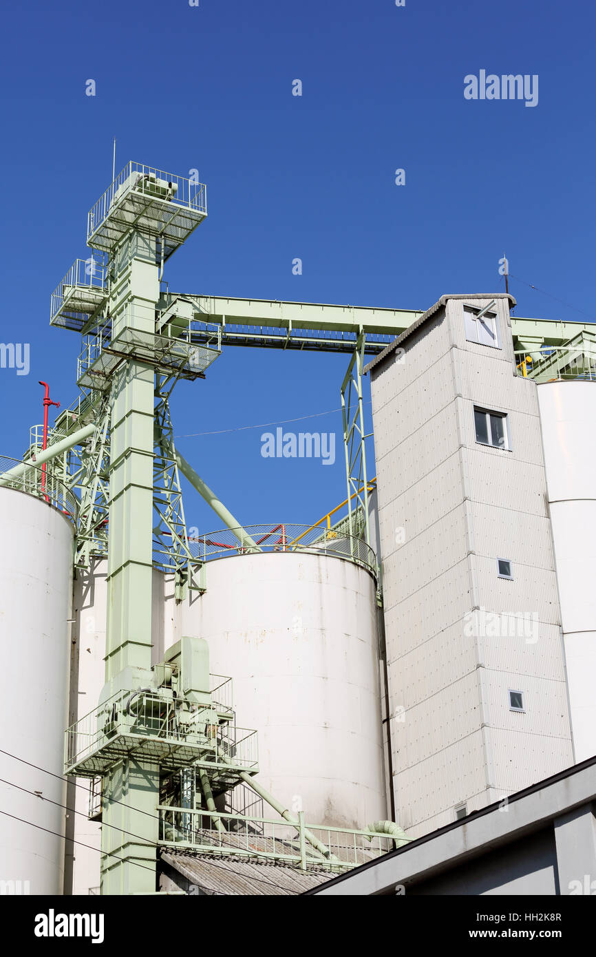 Magazzini industriali e silo di storage contro il cielo blu chiaro Foto Stock