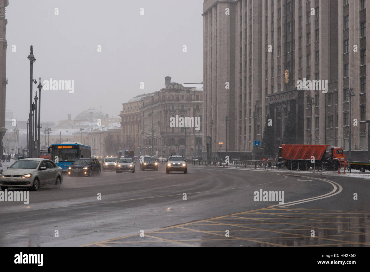 Mosca, Russia. Domenica, 15 gennaio 2017. Il traffico verso il basso il teatro guidare passato il Four Season's Hotel. Neve attività di pulizia di fronte alla Duma - Parlamento russo (destra) bagnato, ventoso e nevoso domenica a Mosca. La temperatura è di circa -2C (28F). Nuvole pesanti, bufera di neve. Pulitori per strada e la pulizia della neve veicoli sono occupato. © Alex Immagini/Alamy Live News Foto Stock