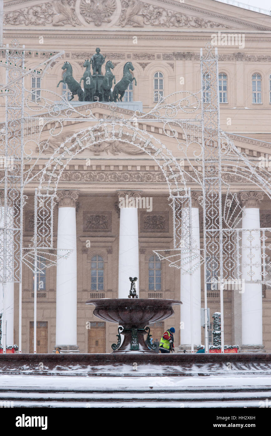 Mosca, Russia. Domenica, 15 gennaio 2017. Fontana di surgelati e le decorazioni di Natale nella parte anteriore del Bolshoi (Grand Theatre. Apollo quadriga sulla parte superiore del tetto. Wet, ventoso e nevoso domenica a Mosca. La temperatura è di circa -2C (28F). Nuvole pesanti, bufera di neve. Pulitori per strada e la pulizia della neve veicoli sono occupato. © Alex Immagini/Alamy Live News Foto Stock