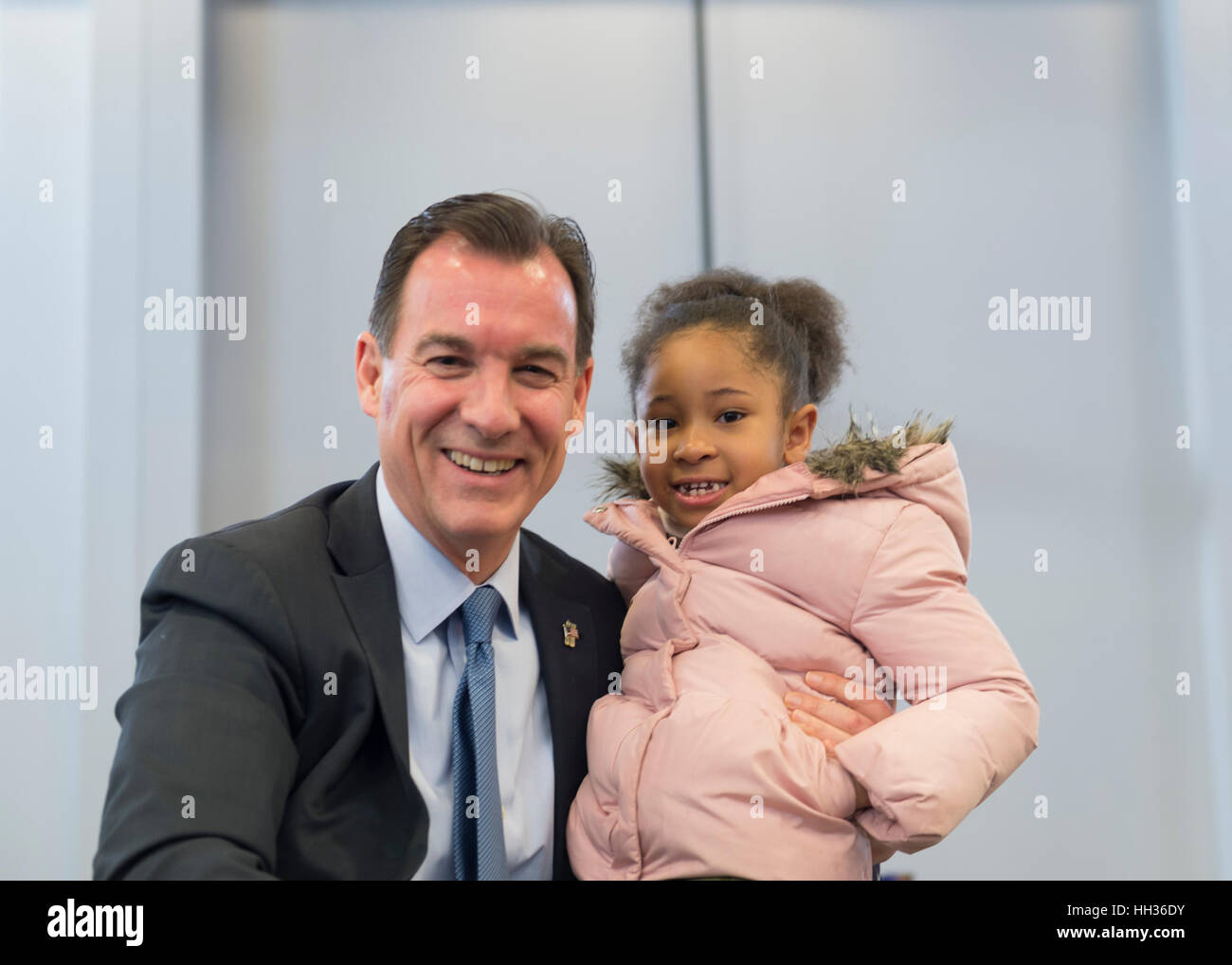 New York, Stati Uniti d'America. 15 gennaio, 2017. Sost. Thomas Suozzi (Democratico - terzo quartiere congressuale) e Sanaa Smith, 5, di Westbury, posa per una foto alla fine dell 'il nostro primo cavalletto' Rally contro i repubblicani che abroga la cura conveniente agire, ACA. Tenendo milioni di persone fuori di assicurazione sanitaria, rendendo massicci tagli a Medicaid e defunding Planned Parenthood. Sanna ha partecipato rally con la madre Naima Smith, che sostiene attivamente per la cura della salute. Essa è stata una delle decine di Bernie Sanders' rally a livello nazionale per la cura della salute che la domenica. Credito: Ann e Parry/Alamy Live News Foto Stock