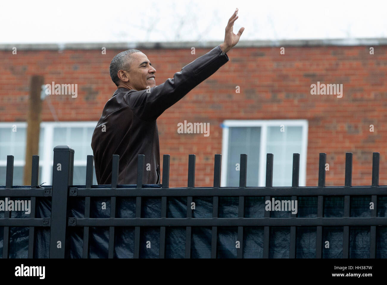 Washington, Stati Uniti d'America. 16 gennaio 2017.Il Presidente Usa Barack Obama si erge su un tavolo da picnic in onda su un recinto per la popolazione locale il tifo per lui, dopo aver partecipato a un evento di assistenza per il Martin Luther King Jr. giornata presso i posti di lavoro hanno priorità Naylor strada rifugio di famiglia. Credito: Michael Reynolds/Piscina via CNP /MediaPunch/Alamy Live News Foto Stock