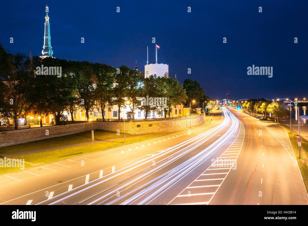 Riga, Lettonia. La vista notturna del 11 novembre terrapieno In illuminazione brillante con Bianco Rosso Motion Blur effetto vicino Castello di Riga nella Città Vecchia in estate Foto Stock