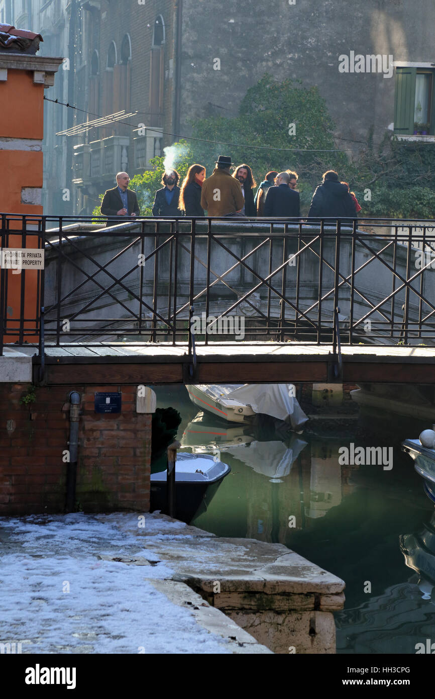 Le persone che attraversano un ponte in inverno, Venezia Italia Foto Stock