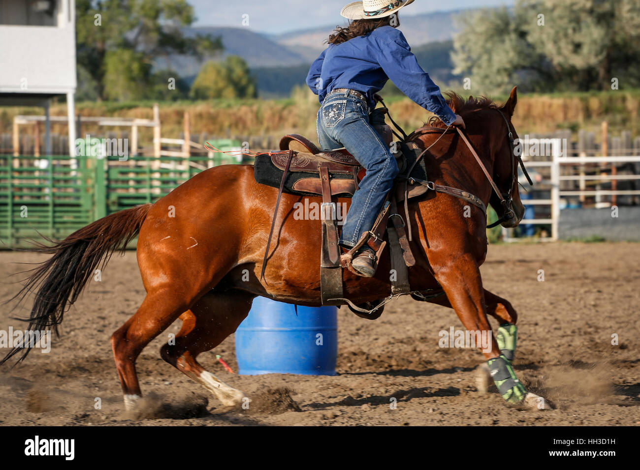 Giovane donna a cavallo Barrel racing durante una gioventù rodeo. Foto Stock