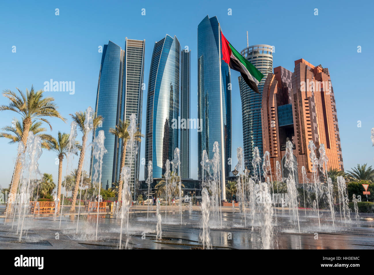 Etihad torri. Edifici moderni sulla Corniche di Abu Dhabi con fontane e bandiera nazionale Foto Stock