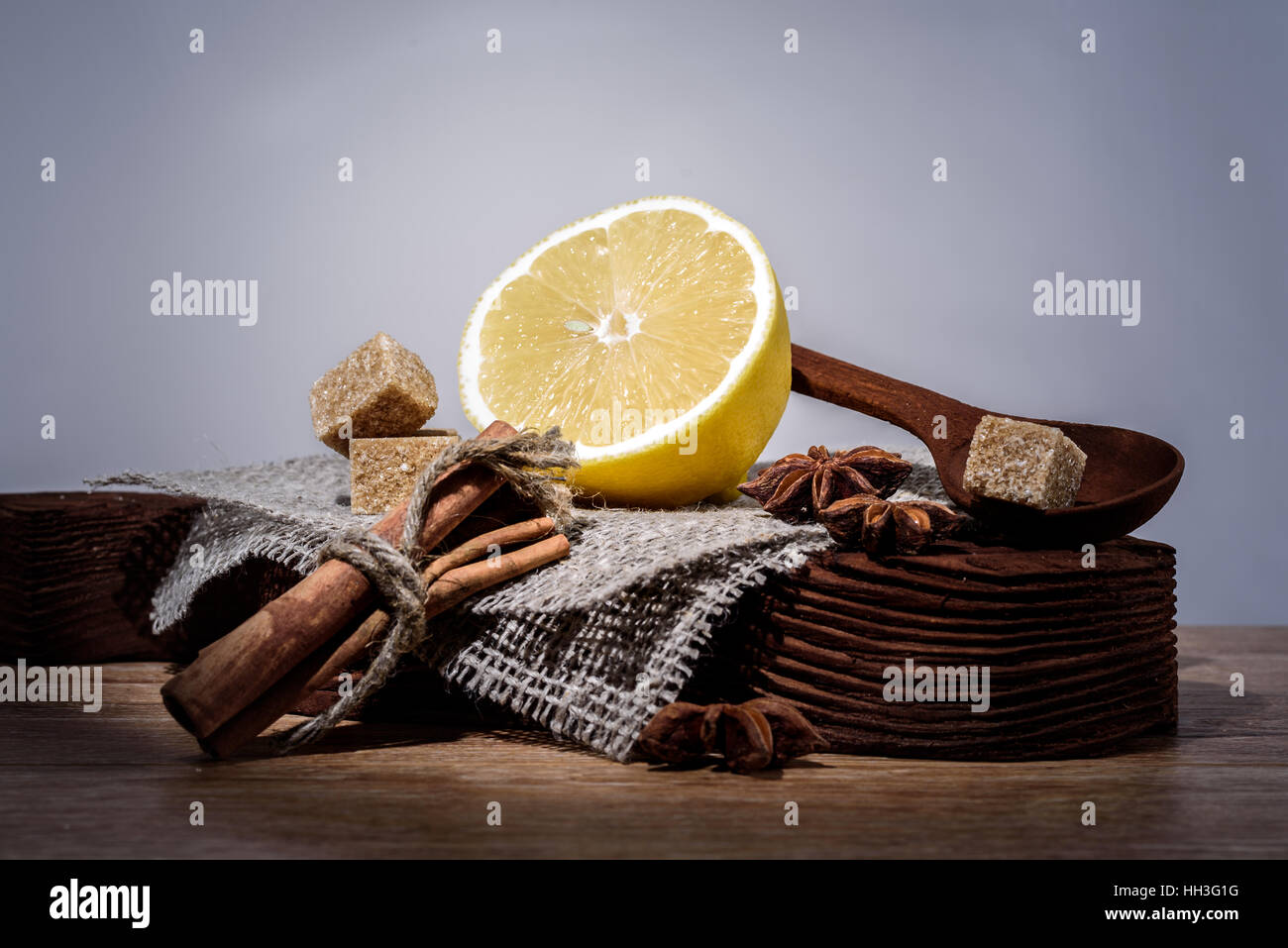 Impostare il limone, anice, cannella, zucchero di canna su una vecchia tavola di legno isolato su sfondo chiaro Foto Stock