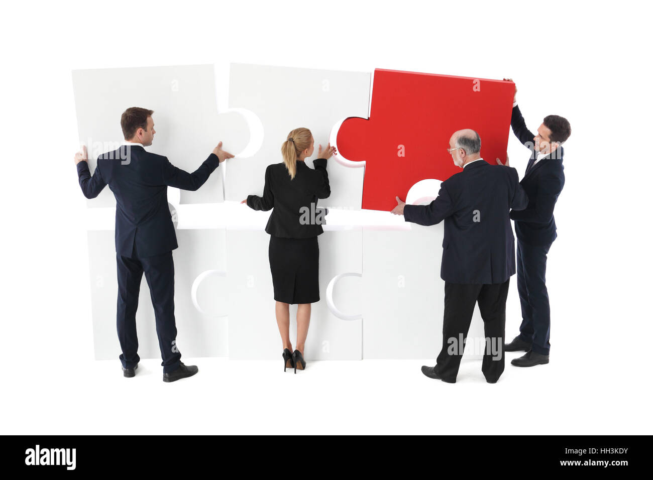 Team Aziende costruisce un nuovo progetto con puzzle, isolato su bianco Foto Stock