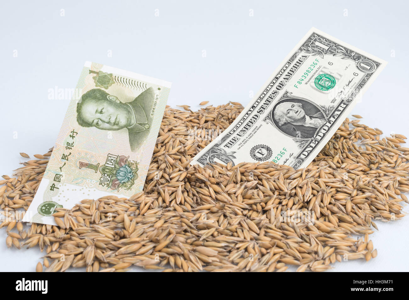 Pila di grano con il cinese 1 Yuan e dollaro banconote / fatture - per il concetto di USA-Cina guerra commerciale / guerra tariffaria dopo i dazi all'importazione sollevata. Foto Stock