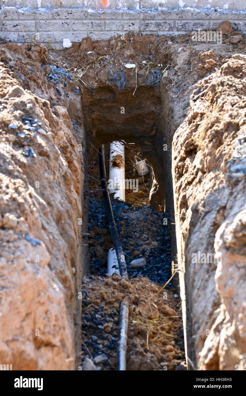 Un grande buco scavato per tubi in una nuova casa residenziale Foto Stock