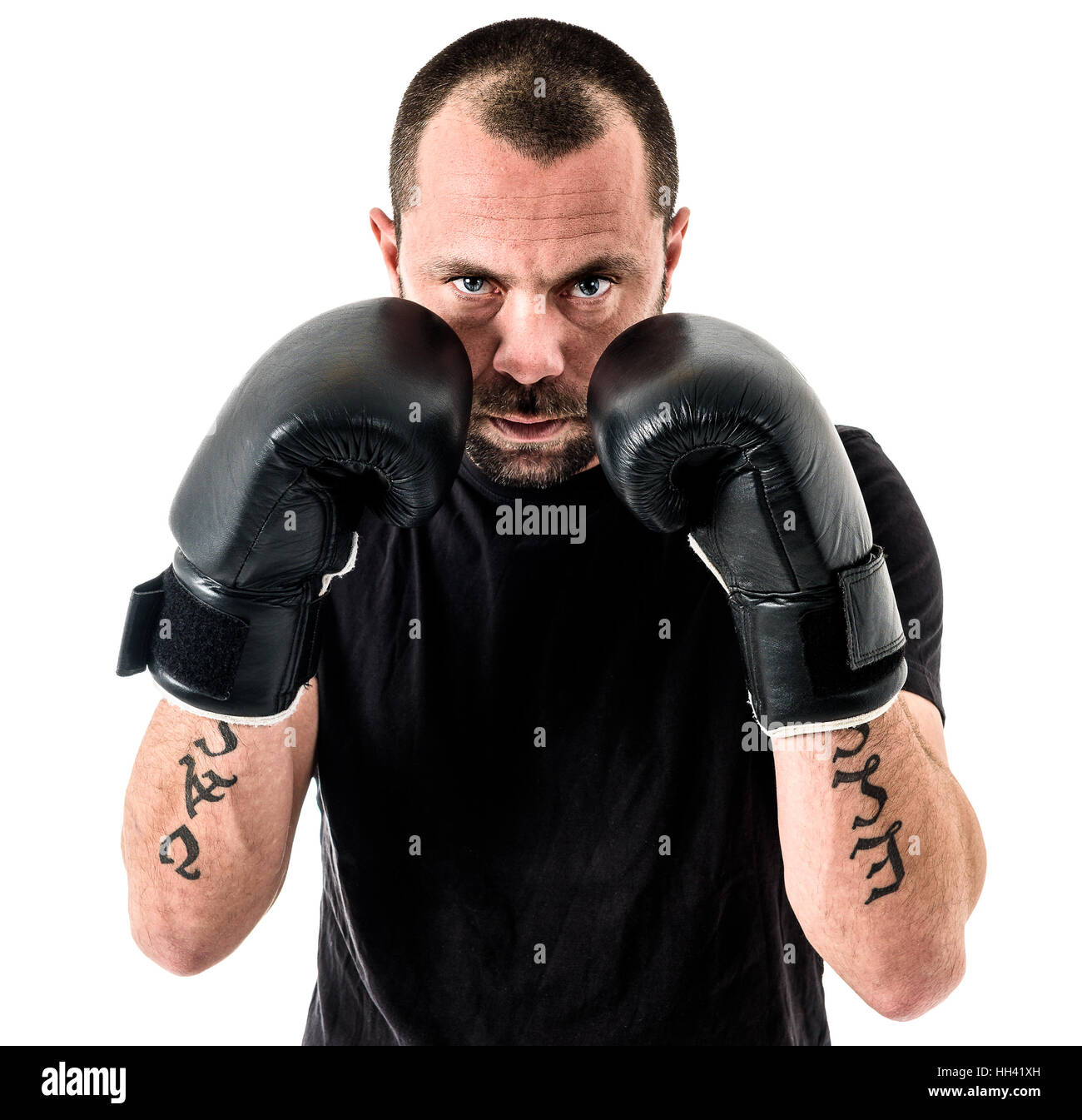 Ritratto di atleta maschio boxer uomo cercando aggressivo con i guantoni,  camicia nera e tatuaggi. Isolato su sfondo bianco Foto stock - Alamy