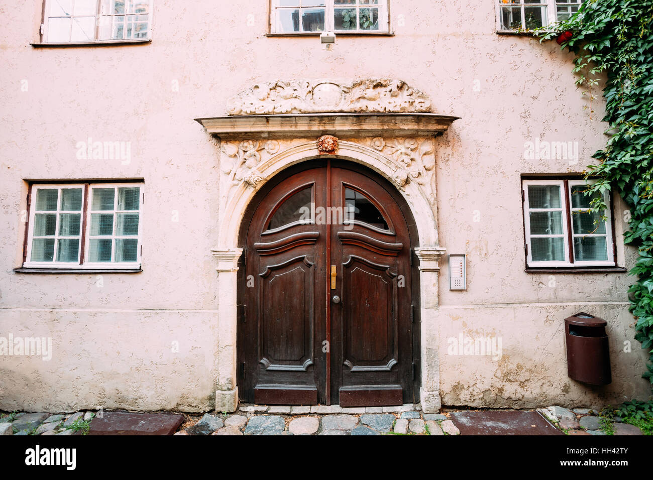 Riga, Lettonia. Il vecchio legno marrone Porta del portale decorato da stampaggio sulla facciata del palazzo antico su Torna Street nella città vecchia nel giorno d'estate. Foto Stock