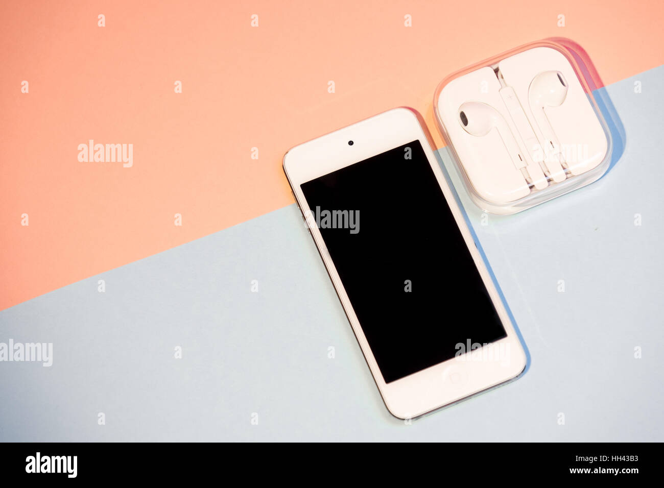 Smart phone e cuffie contro rosa e aqua sfondo Foto Stock