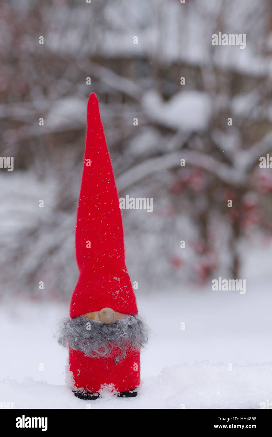 Un divertimento poco amorevole gnome gioca all'aperto nella neve Foto Stock