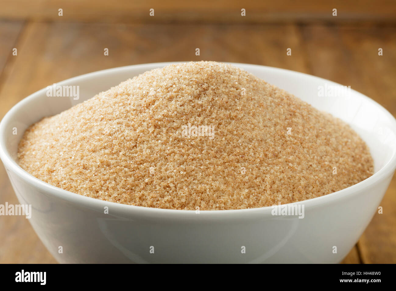 Lo zucchero di canna nel recipiente bianco sul tavolo di legno Foto Stock