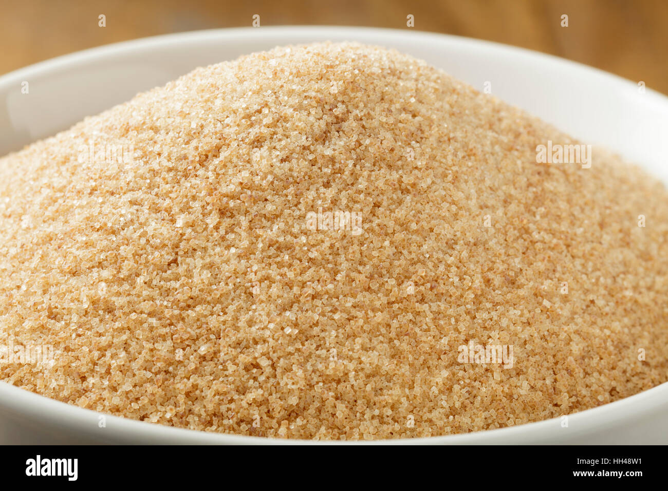 Lo zucchero di canna nel recipiente bianco sul tavolo di legno Foto Stock