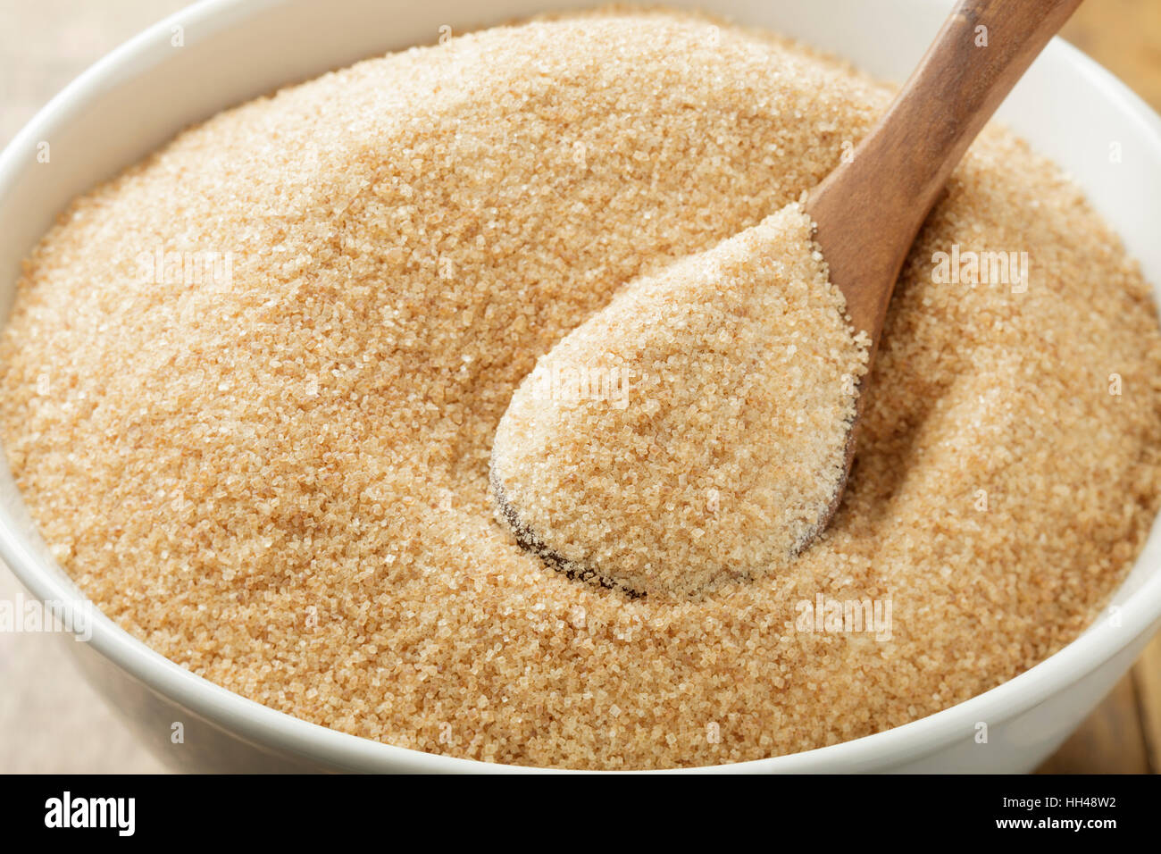 Lo zucchero di canna nel recipiente bianco sul tavolo di legno Foto Stock