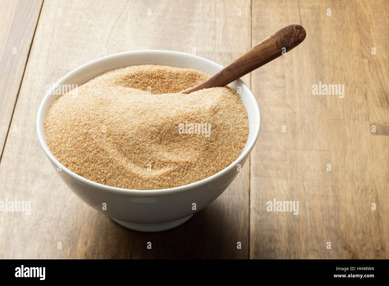 Lo zucchero di canna nel recipiente bianco sul tavolo di legno Foto Stock