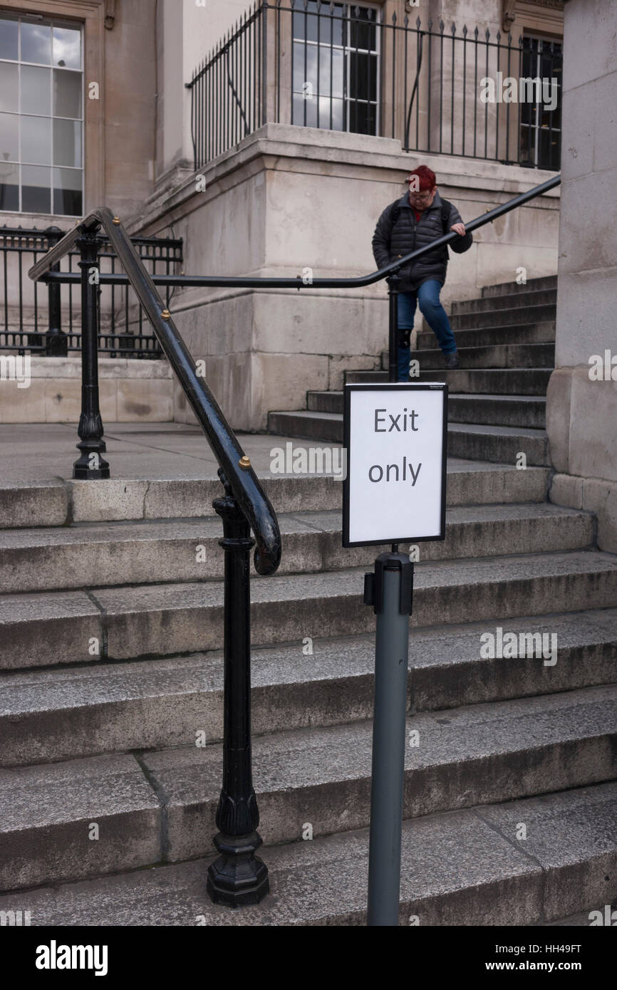 Una donna scende con cautela le fasi, con un'uscita solo segno sui gradini della National Gallery, il 11 gennaio 2017, a Trafalgar Square a Londra, Inghilterra. Foto Stock