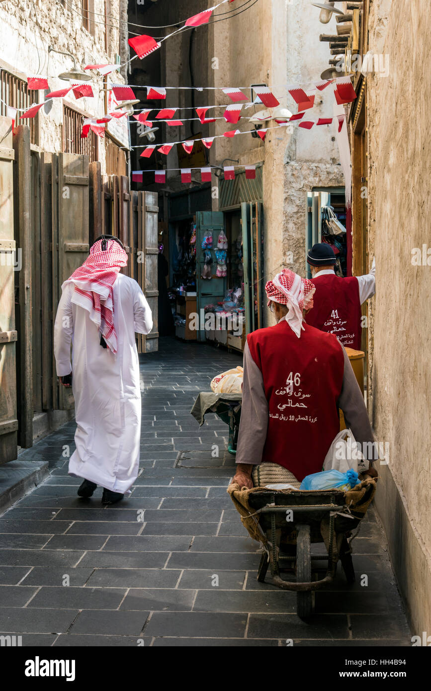 Tradizionalmente vestito uomo arabo a piedi nei Souq Waqif, Doha, Qatar Foto Stock