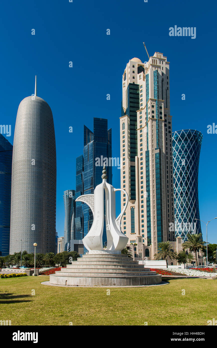 Caffè arabo pot scultura con business district skyline dietro, Doha, Qatar Foto Stock