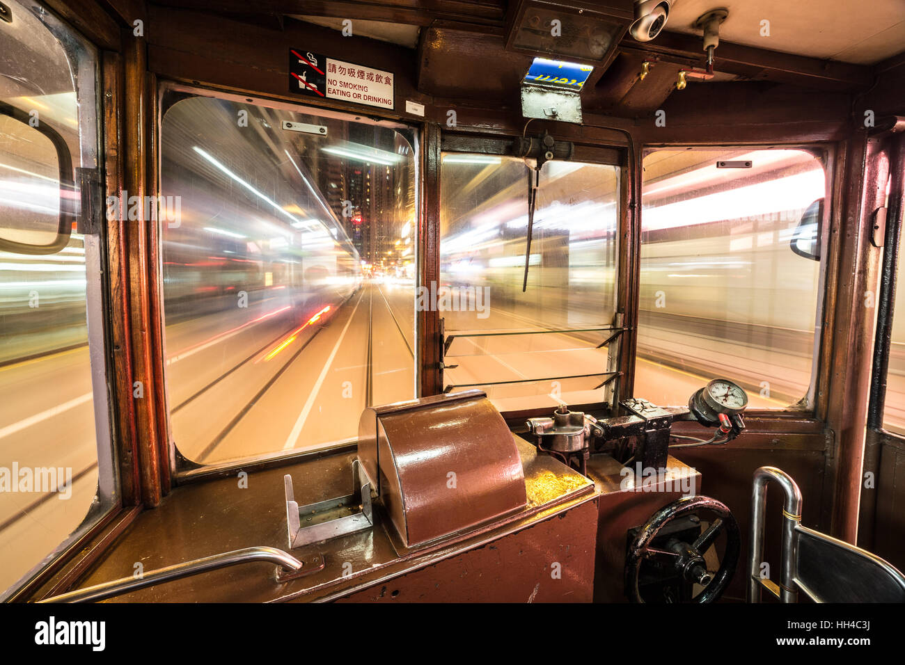 All'interno di un Tram auto correre attraverso Hong Kong Island strade di notte. Ampio angolo e una lunga esposizione sono utilizzati. Foto Stock