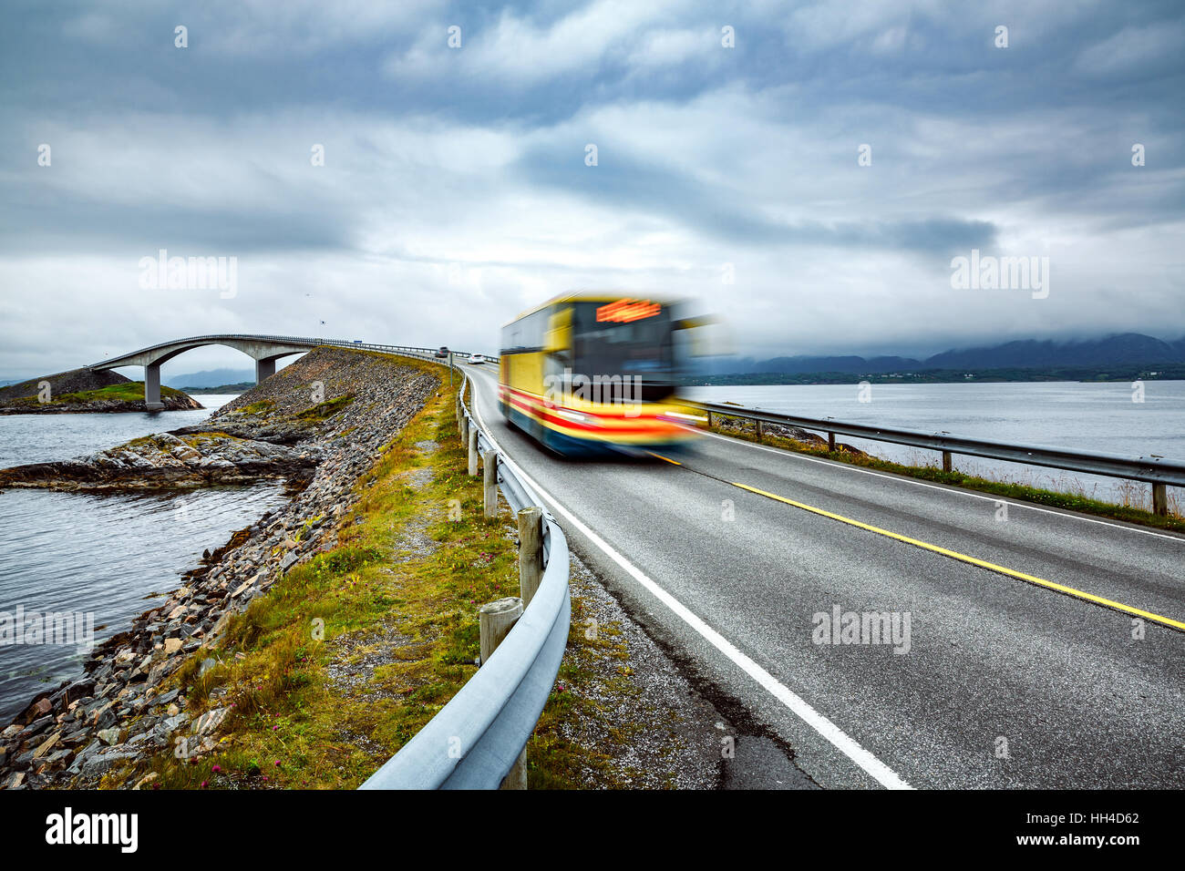 Bus pubblico viaggia su strada in Norvegia. Bus pubblico in motion blur. Oceano atlantico su strada o la strada atlantica (Atlanterhavsveien) stato aggiudicato il t Foto Stock