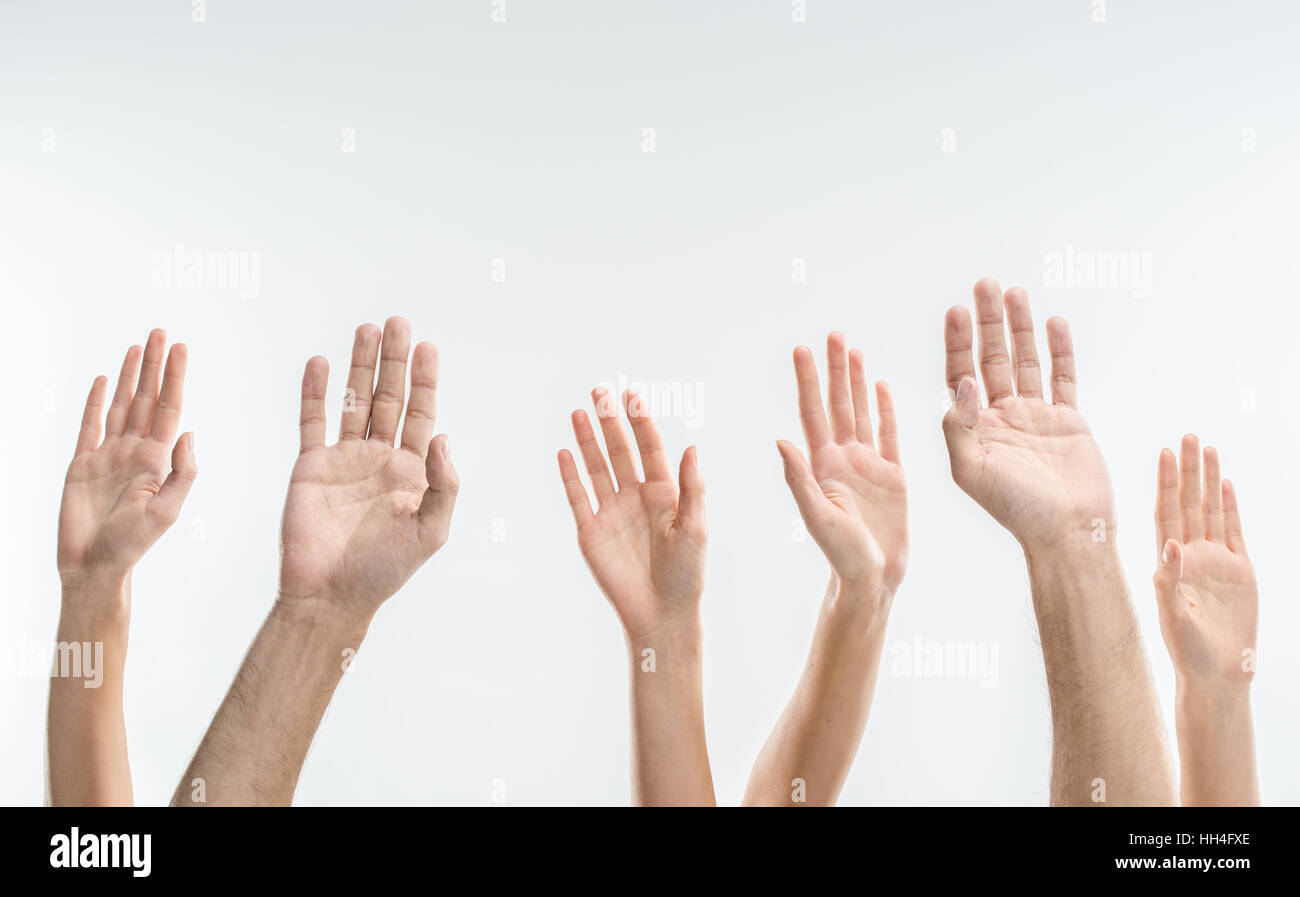 Vista parziale di persone alzando le mani su bianco Foto Stock