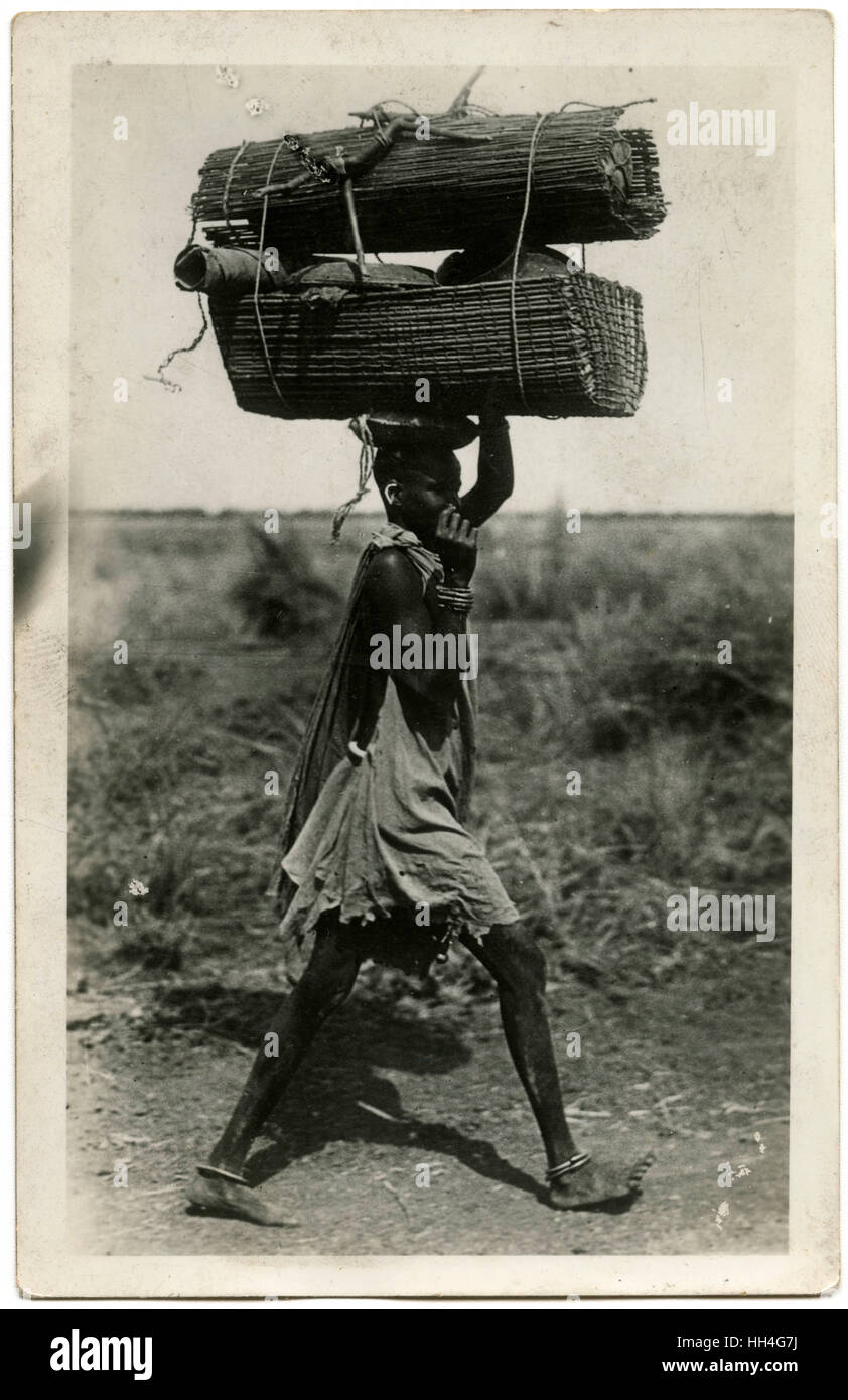 Trasporta un carico pesante sulla testa - Sudan. Foto Stock