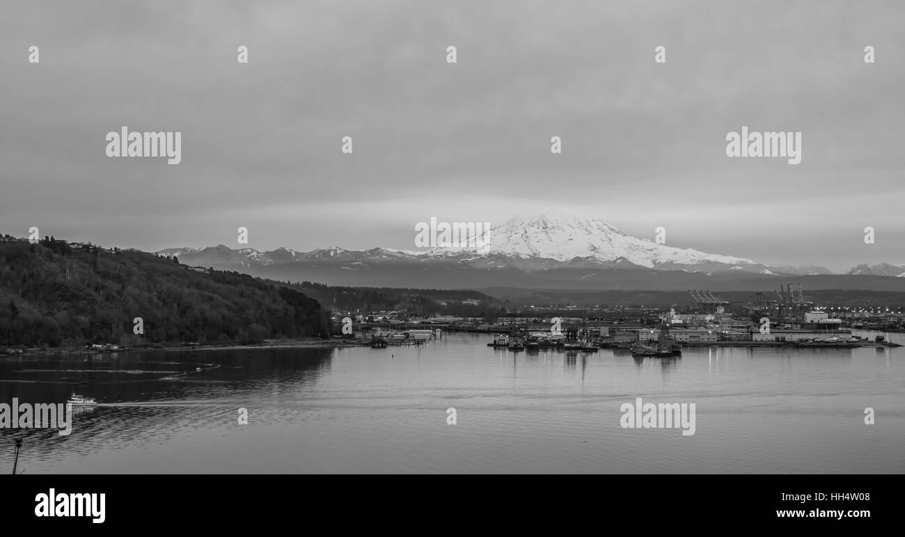 Le nubi coprono la parte superiore di una neve-laden Mount Rainier. Porto di Tacoma è qui di seguito. Foto Stock
