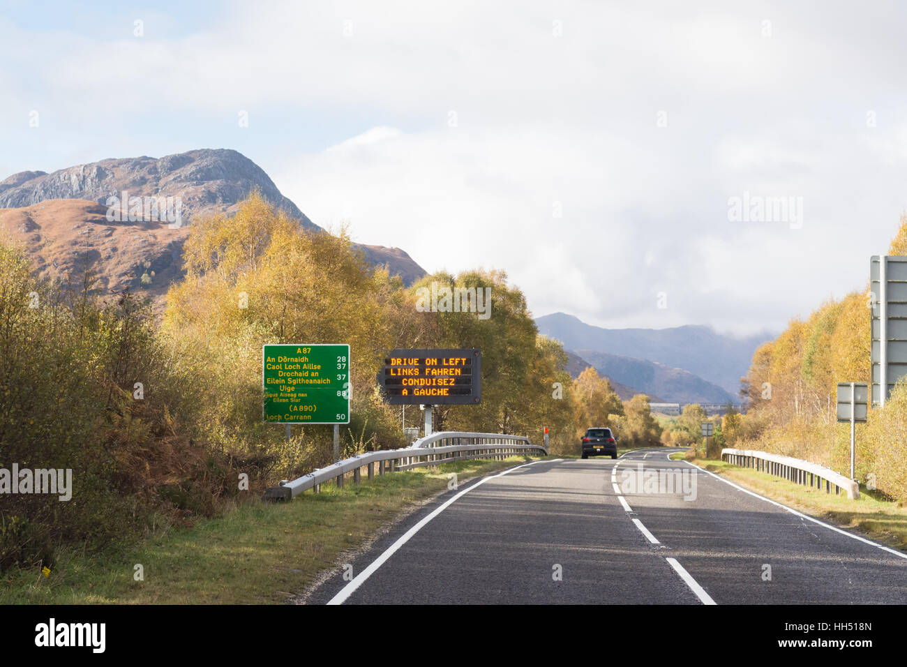 Guidare a sinistra cartello stradale e il gaelico cartello stradale sulla A87 nelle Highlands scozzesi, Scotland, Regno Unito Foto Stock