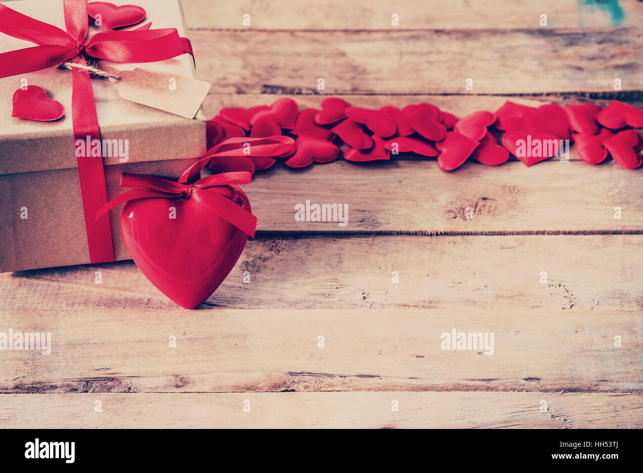 Confezione regalo e cuore rosso sul tavolo di legno con uno spazio Foto Stock