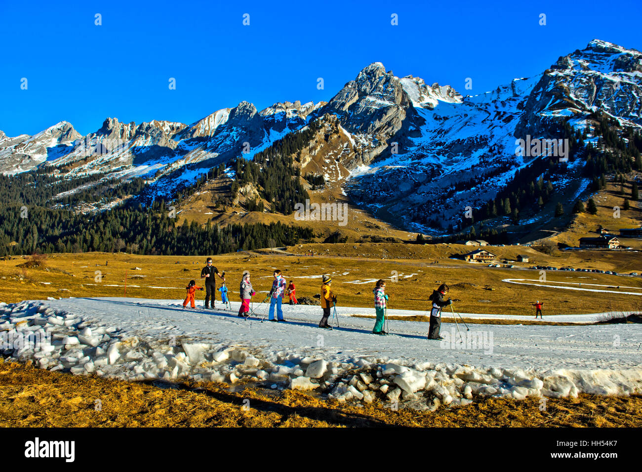 Gruppo di ragazzi practicising sci di fondo corre sul fatto di neve artificiale, La Clusaz, Alta Savoia, Francia Foto Stock