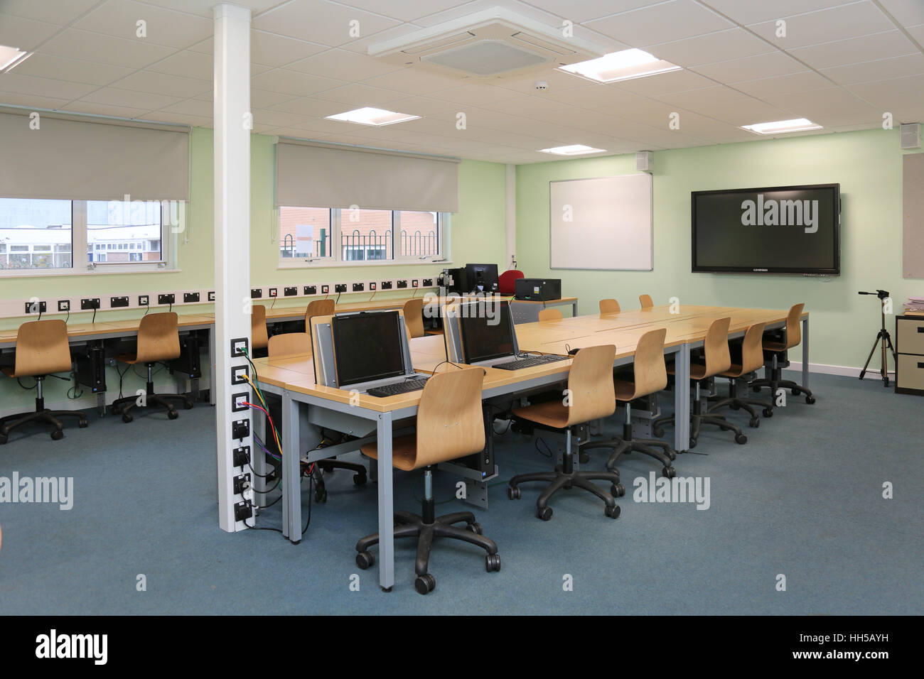 Postazioni computer in una nuova scuola secondaria in aula di tecnologia. Mostra i computer nascosto in speciali banchi di piegatura Foto Stock