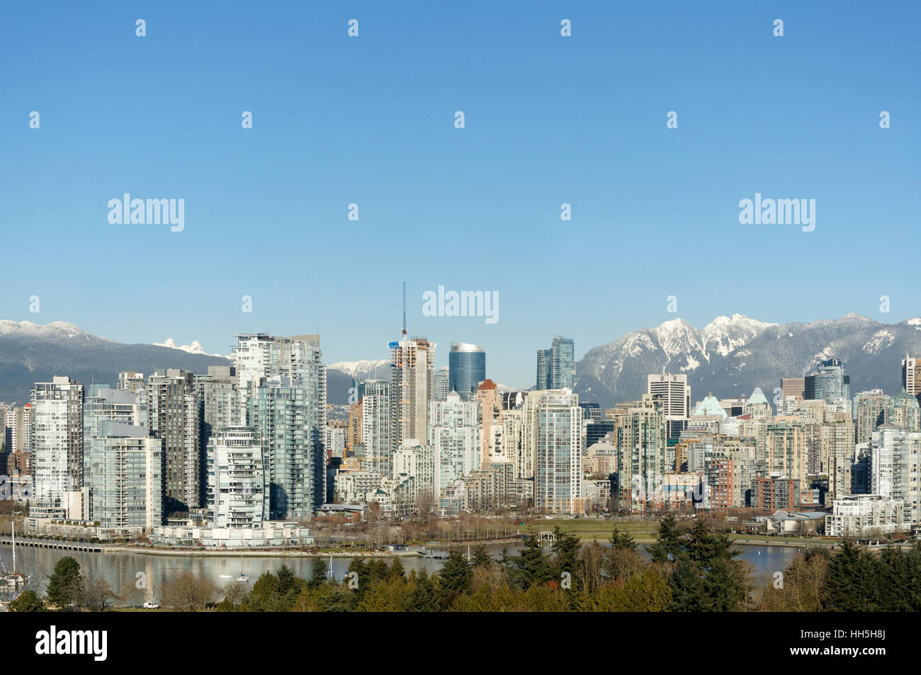 Skyline di Vancouver con False Creek in primo piano innevato North Shore montagne sul retro, Vancouver, British Columbia, Canada Foto Stock