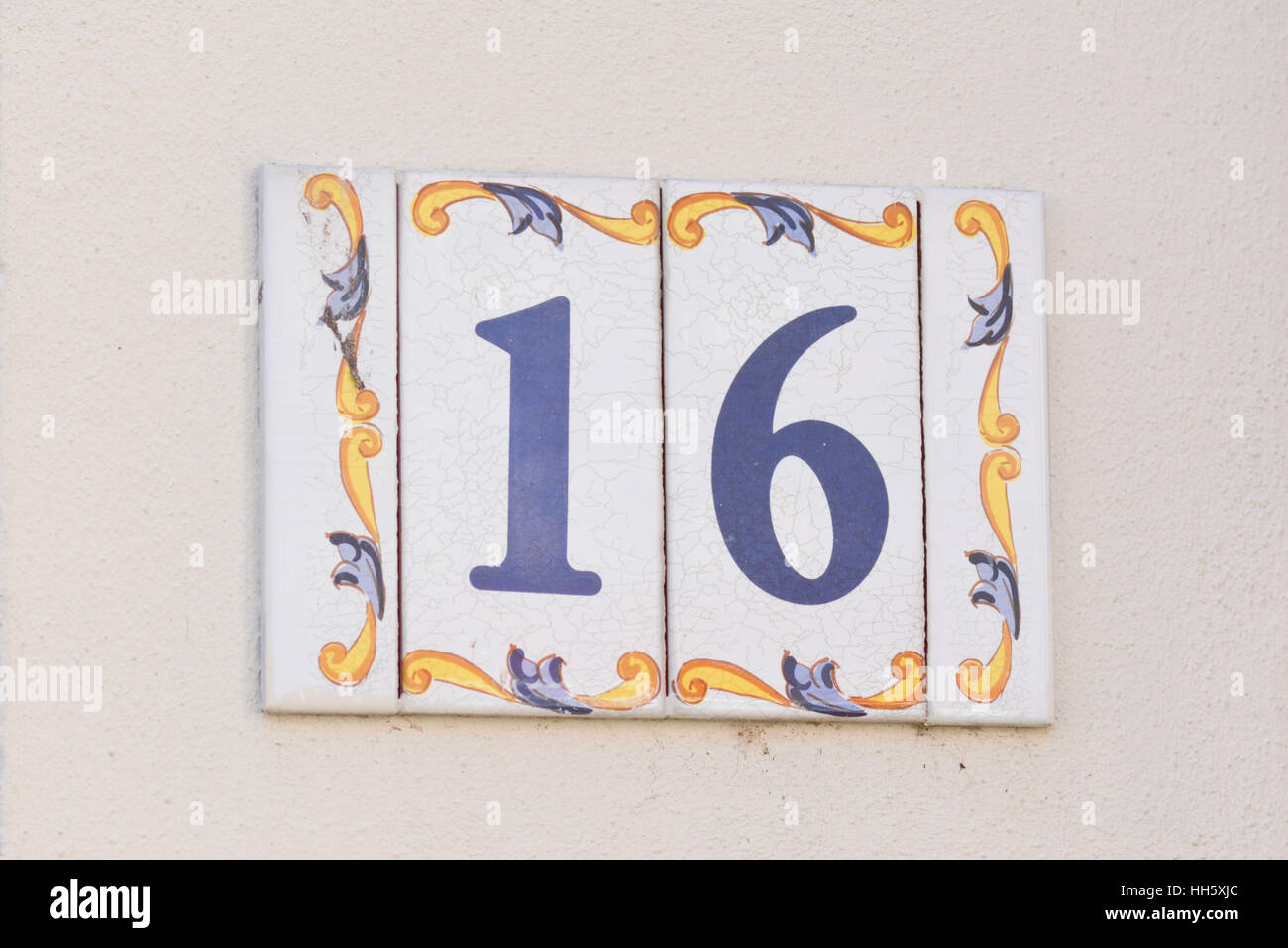 Il numero civico 16 segno sulla parete Foto Stock Il numero civico 16 segno sulla parete Foto Stock