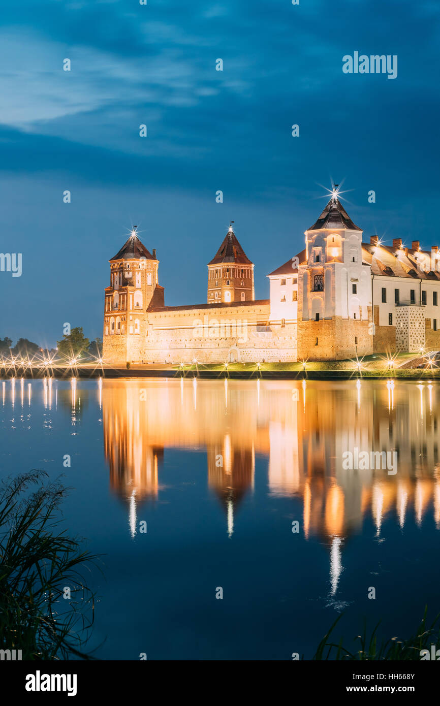 Mir, Bielorussia. Una vista pittoresca del complesso del Castello di Mir In brillante illuminazione serale con candelette di riflessioni sul lago di acqua. Famoso punto di riferimento, antica Gothi Foto Stock