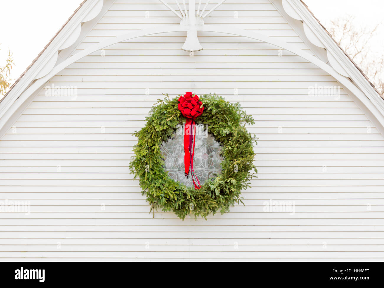 Ghirlanda di Natale appeso all'esterno di un vecchio edificio bianco con interessanti dettagli architettonici Foto Stock