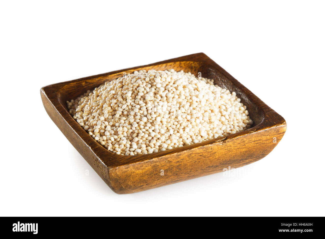 La quinoa in ciotola di legno isolato su sfondo bianco Foto Stock