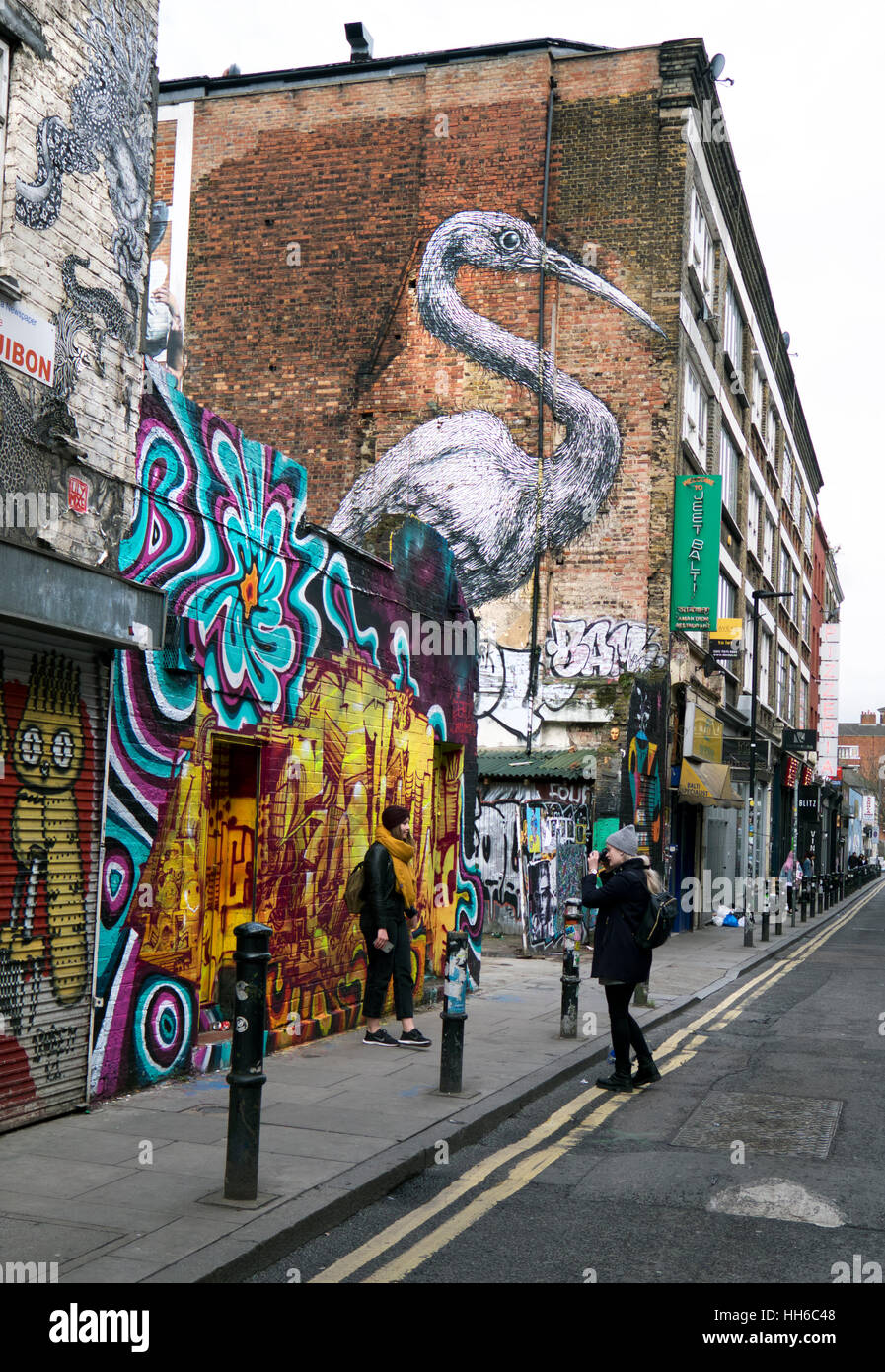 Arte di strada da Martin Ron raffiguranti Queens Guard esecuzione di Capoeira e sacro gru su strada Hanbury Street nr Brick Lane East Lo Foto Stock
