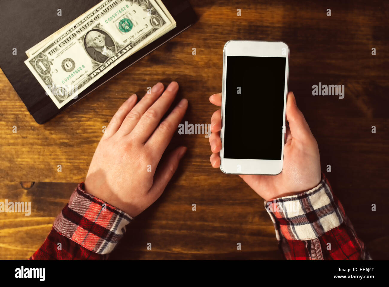 Donna che utilizza smart phone, mock up schermo come copia di spazio, vista dall'alto della scrivania in ufficio Foto Stock